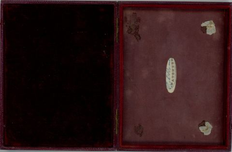 Case. An open case lined with red fabric has a long oval label to our right with the name “Beard” signed over the printed word “Patentee”.