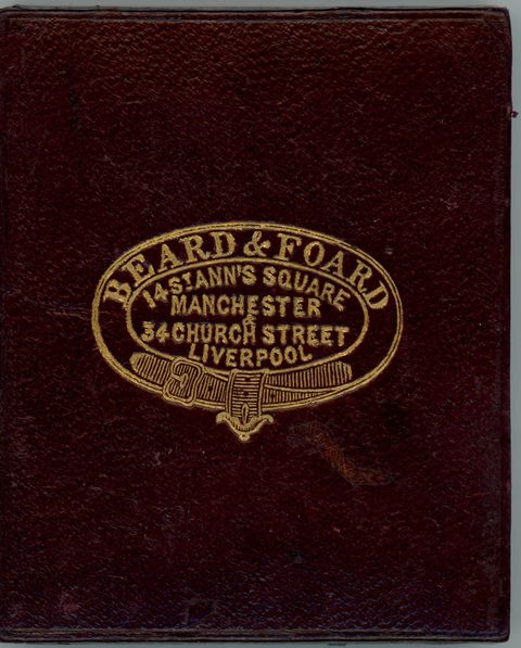 Case. Burgundy-red leather case is stamped with a gold insignia and text.