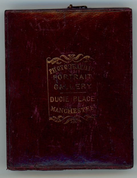 Case. Burgundy-red leather case embossed with gold text that begins, “Photography Portrait Gallery” above the location.