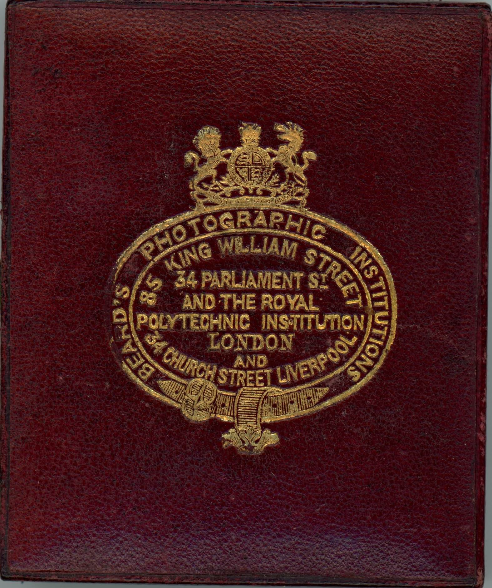 Case. Burgundy-red leather case is stamped with a gold insignia and text.