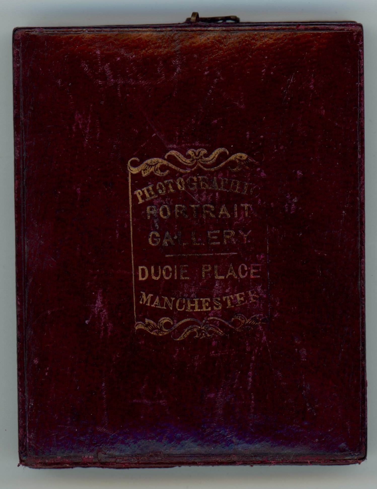 Case. Burgundy-red leather case embossed with gold text that begins, “Photography Portrait Gallery” above the location.