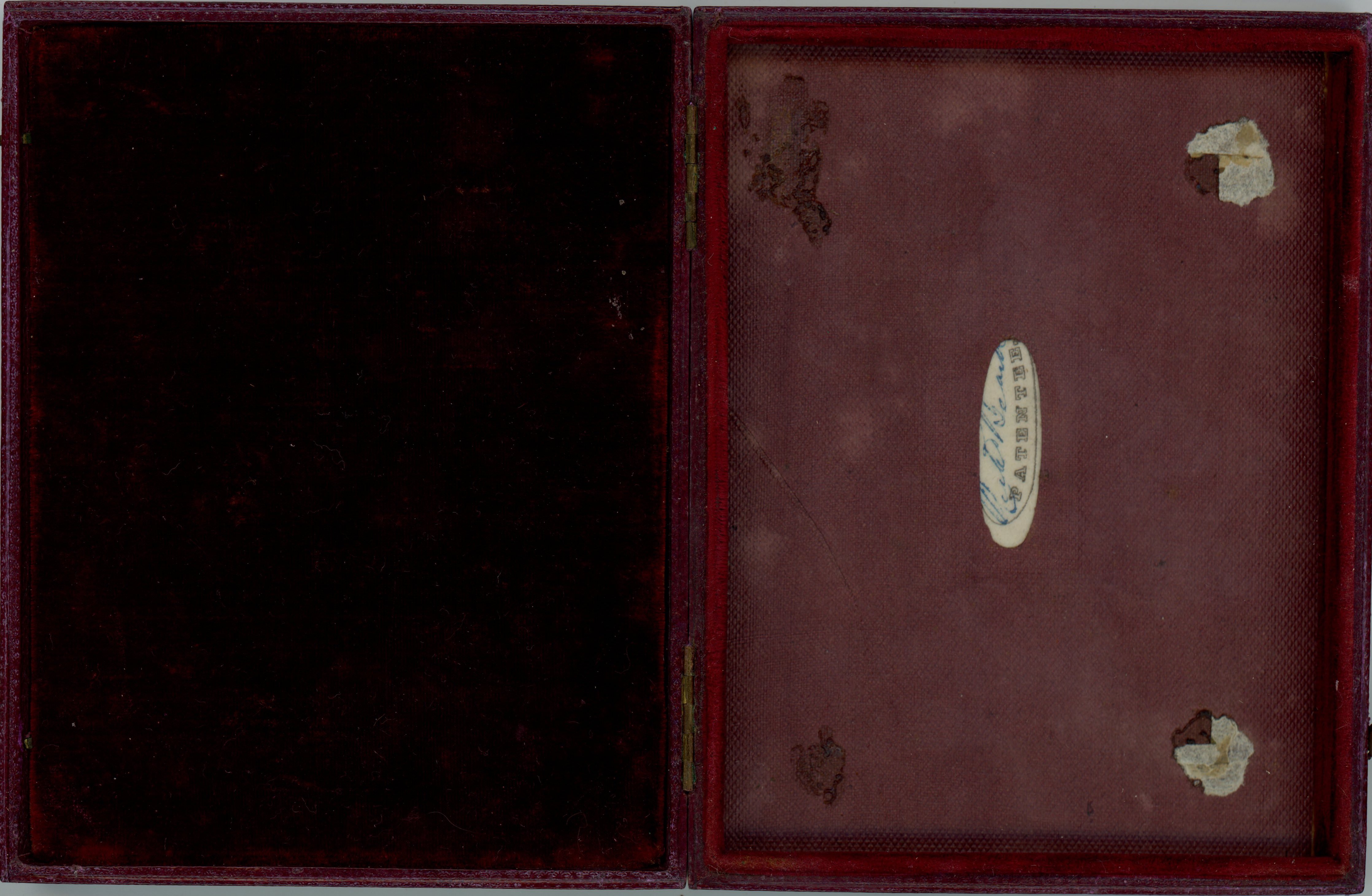 Case. An open case lined with red fabric has a long oval label to our right with the name “Beard” signed over the printed word “Patentee”.
