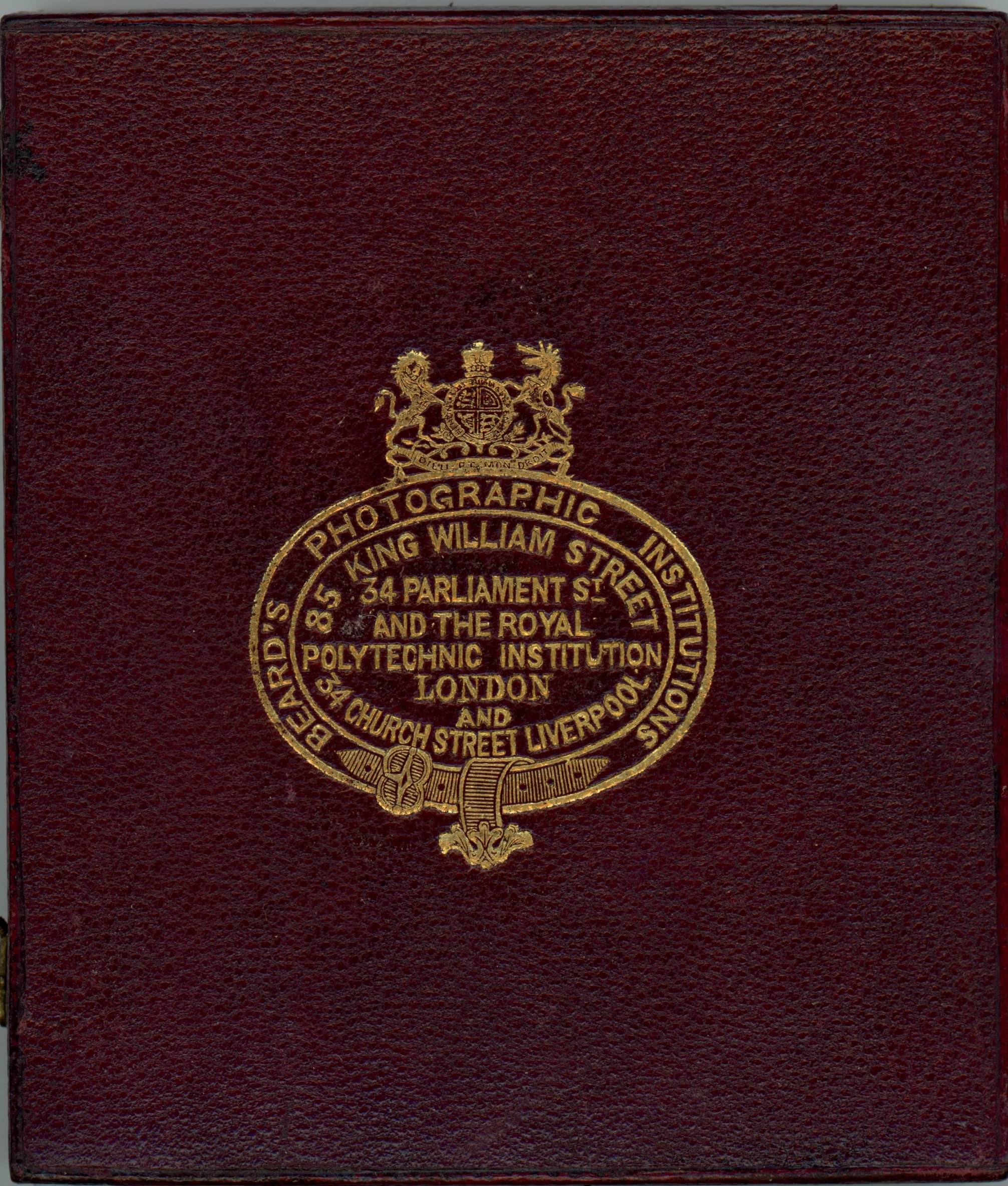 Case. Burgundy-red leather case is stamped with a gold insignia. Text around the border reads, “Beard’s Photographic Institutions”. Text within the insignia reads, “85 King William Street 34 Parliament St and the Royal Polytechnic Institution London and 34 Church Street Liverpool”.