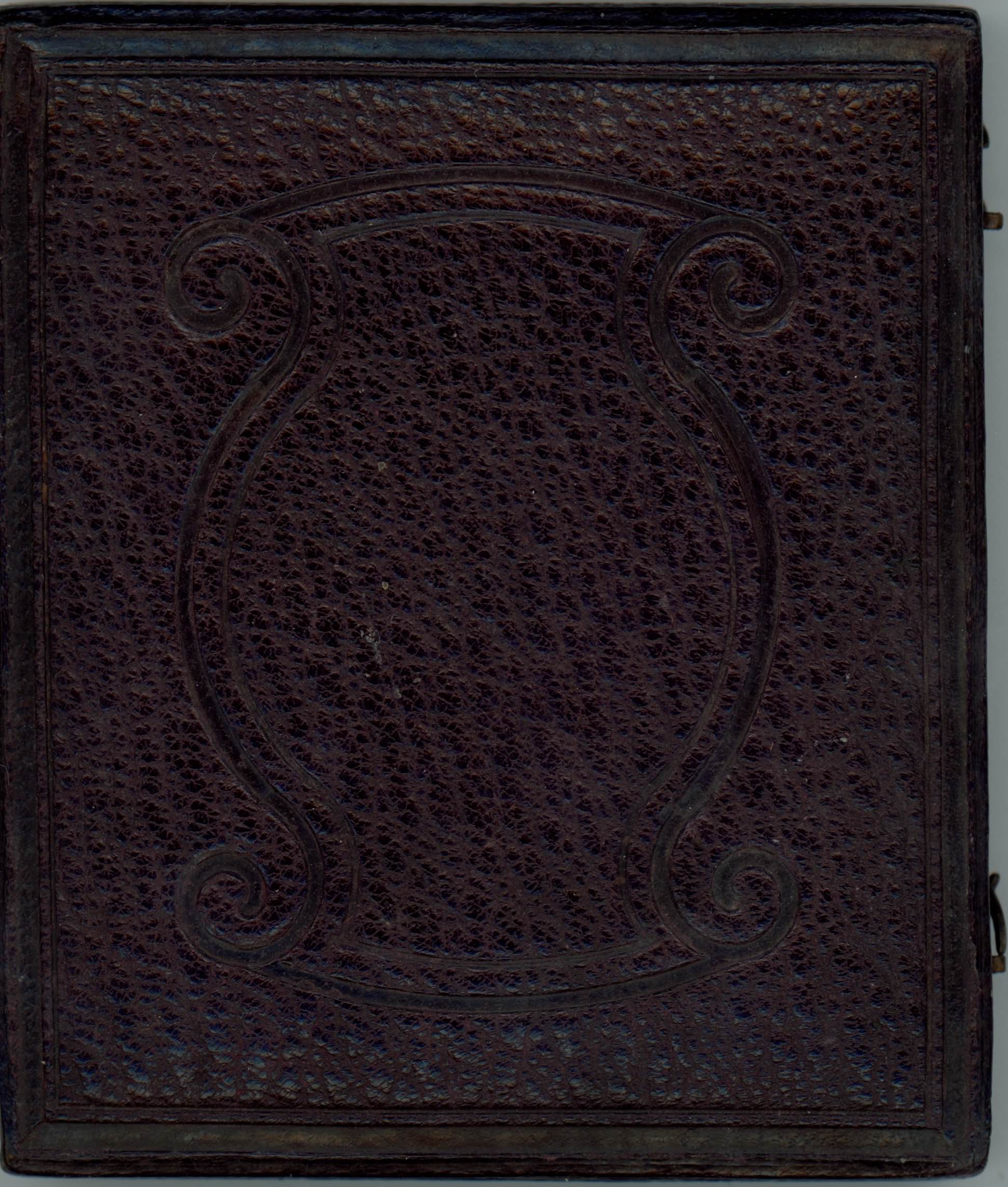 Dark brown leather case is tooled with ornamental design of parentheses-shaped bands.