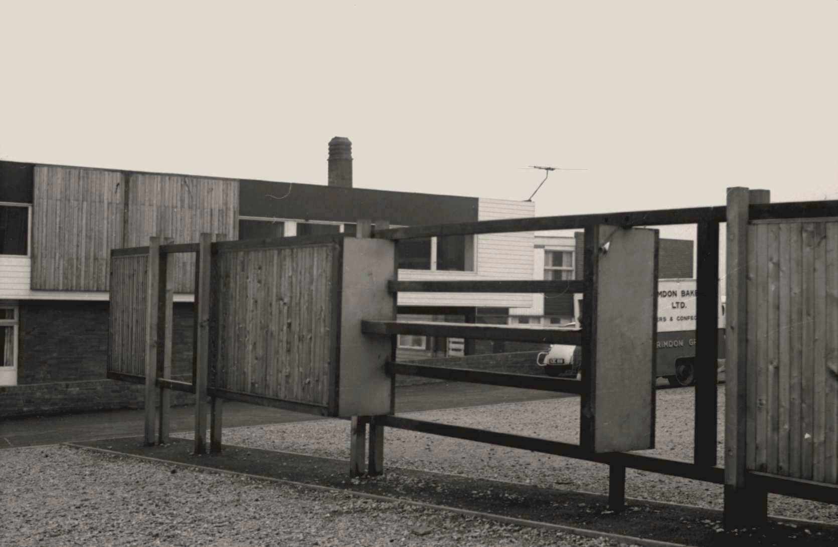 Architecture. A wall-like structure alternates sections of vertical panelling with empty space and horizontal boards in this black and white photograph.