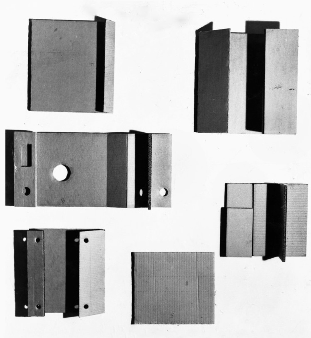 Sculpture. Six works are made of cardboard folded like books or door hinges. Some are pierced with holes.