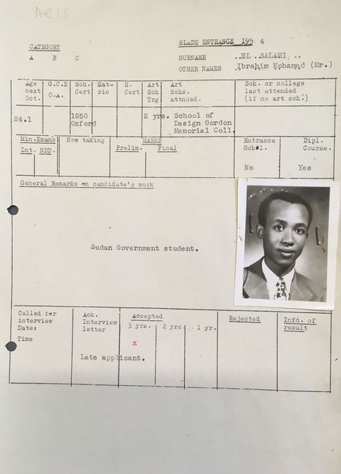Typewritten form. A passport-sized, black and white photograph of Ibrahim El-Salahi wearing a suit and tie is stapled to a school form. Slightly smiling, he has dark skin, short black hair, a high forehead, and a pointed chin.