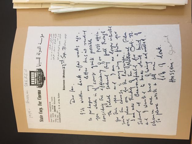 Letter. In blue handwritten ink, a letter begins, “Dear Ian, I've written back a few weeks ago…” and ends, “So please write and tell me. Lots of love, Hussein”. The letterhead reads “State Corp. For Cinema” to our left of a logo and Arabic writing is to the right.
