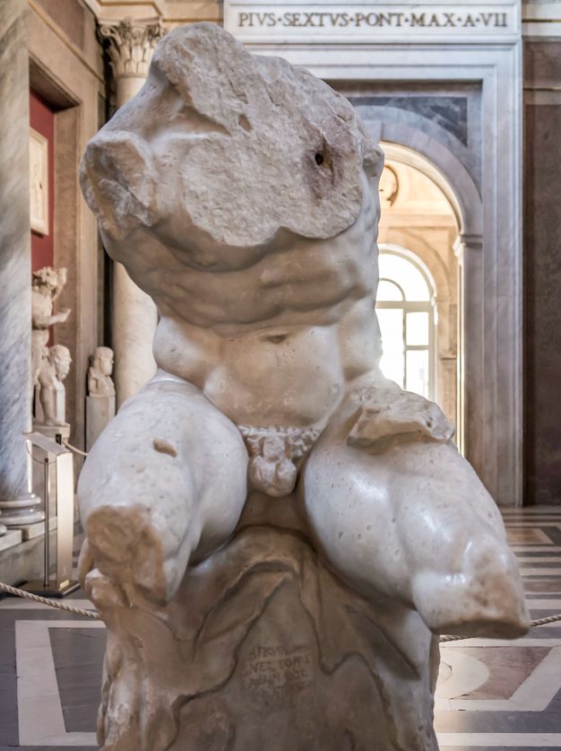 Sculpture. This freestanding statue shows a man’s muscled torso. The head, arms, and legs below the knee are missing. The shoulders are tipped sharply down and to our left towards that raised leg.
