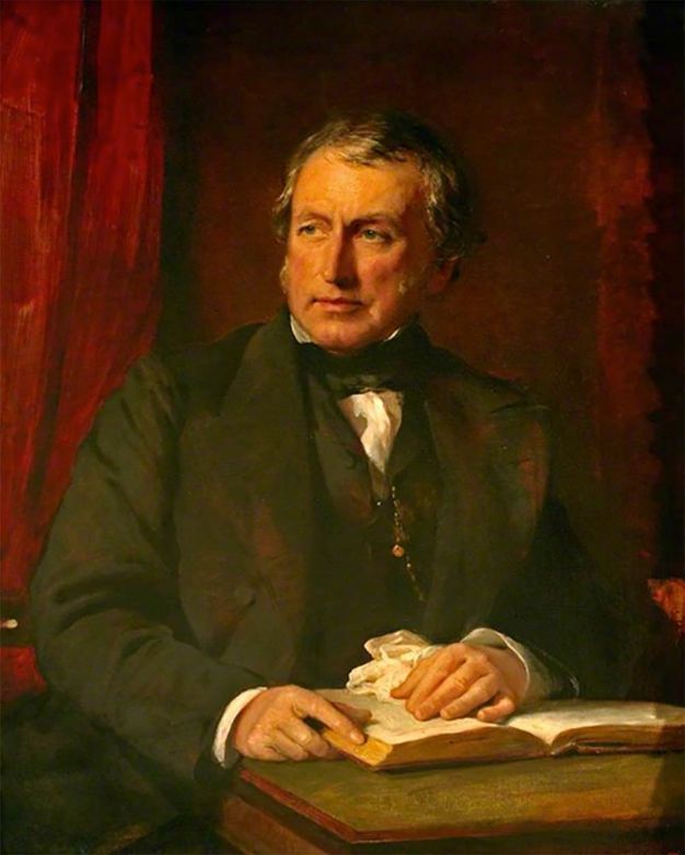 Painting. Shown from the waist up, a pale-skinned man sits behind a table with his hands on an open book. His shoulders square towards us, and he looks off to our left with grey eyes. He has a straight nose, and his wide jaw is lined with thin mutton chops. A ruby-red curtain fills the background behind him.