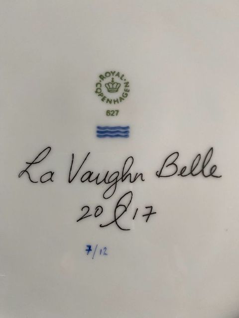 Plate. Detail view of the underside of a white porcelain plate. An insignia for Royal Copenhagen is above La Vaughn Belle’s signature and the date. The plate is numbered below, “7/12”.