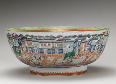 Porcelain. A wide bowl sits on a low, straight-sided foot. The outside of the bowl is painted with buildings lining a street with people.