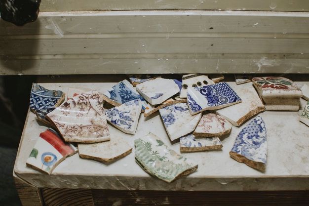 Porcelain. About twenty fragments of porcelain are painted blue, moss green, brown, or other colours.