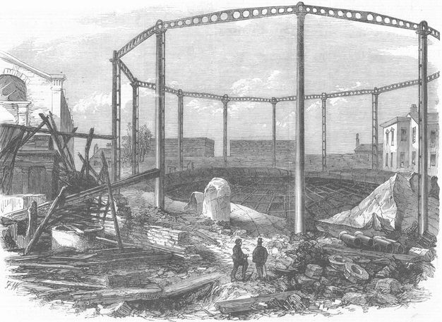 Print. The walls of a polygonal building have been blasted away by an explosion that blackened some of the structures nearby. Two men look at the damage at the bottom centre of the engraving.