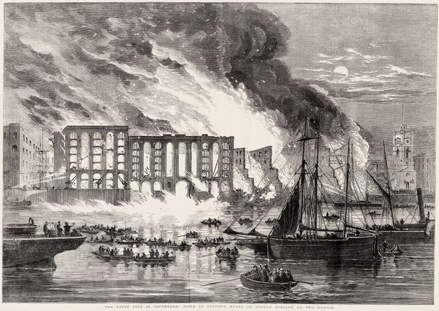 Print. Flames of a blazing fire fill several storeys of a shell of a building. People watch from rowboats on the river. Dark smoke pours into the moonlit sky in this engraving.