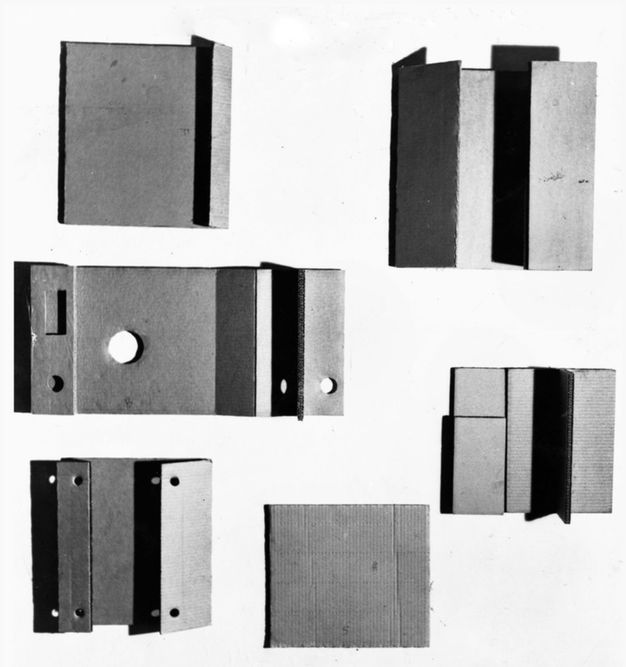 Sculpture. Six works are made of cardboard folded like books or door hinges. Some are pierced with holes.