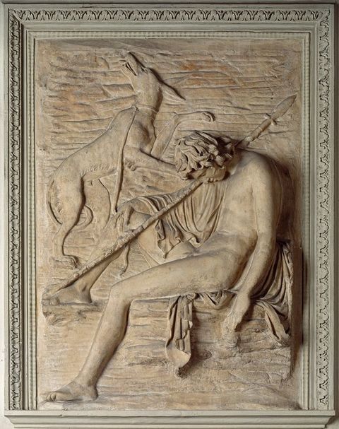 Sculpture. Carved in low relief, a mostly nude young man sits with this head dropped forwards in sleep. One foot is propped up, and a spear rests against that knee and over the shoulder. A dog above the boy turns and looks up, its tail between its legs. One paw appears to be on the boy’s shoulder, and the other is lifted.