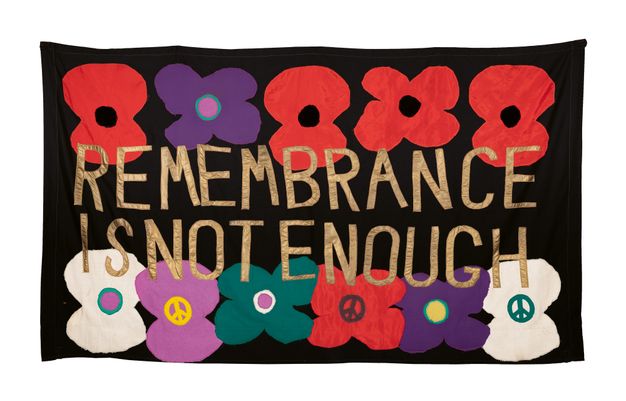 Textiles. Red, purple, blue, green, and white flowers are in two lines against a black background. The title is in gold fabric across the centre of the banner.