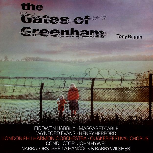 Album cover. A pale-skinned woman and girl hold hands on the far side of a chain-link fence topped with barbed wire. Both have long blond hair, red coats, and they hold hands.