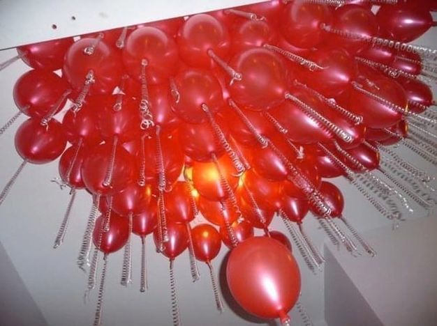 Installation. We look up at dozens of red balloons with what appear to be clear phone cords hanging from the necks.