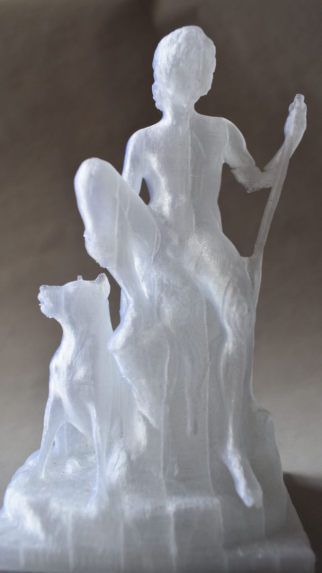 3D printed model. Made with translucent plastic, a boy sits with one foot propped up on a rock. He holds onto that shin with one hand and the other rests on a walking stick. A dog sits next to the rock. The area below the elbow holding the walking stick appears crumpled or damaged.