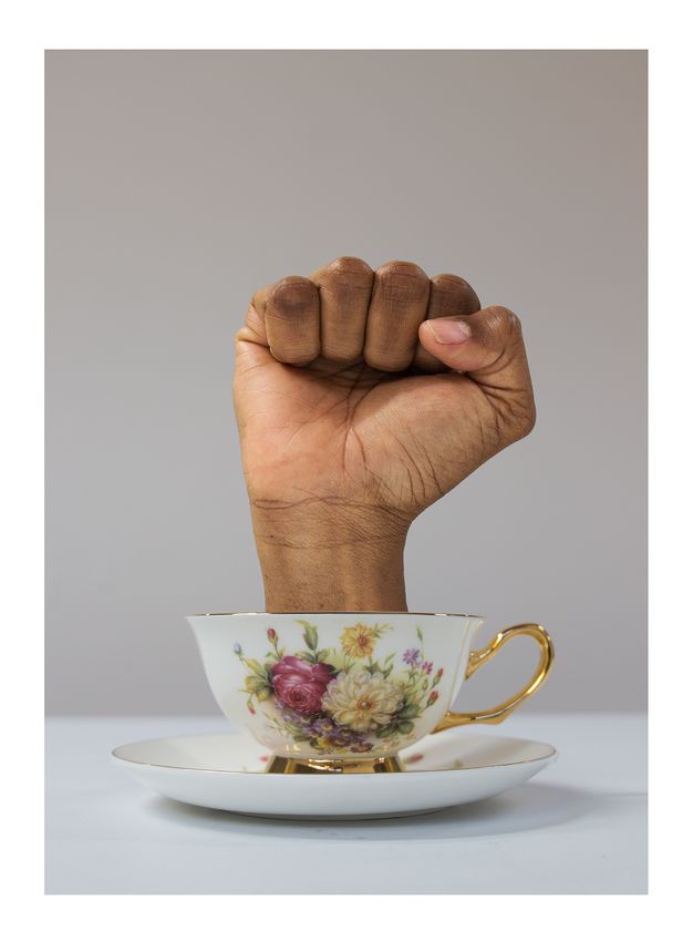 A fourth iteration in the series, where the hand is fully clenched into a fist, emerging from the teacup.