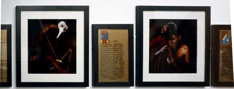 Installation photograph. Five framed artworks hang closely together on a wall. The two on either side are cropped, while the three in the centre can be seen clearly. Two are colour photographs featuring people with a dark skin tone in theatrical costume, while the third is an illuminated text.