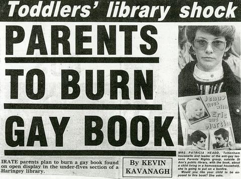 Newspaper clipping. An excerpt from a newspaper clipping has a headline that reads, “Toddlers’ library shock: PARENTS TO BURN GAY BOOK.” A subheading describes how “irate parents plan to burn gay book found… in the under-fives section of a Haringey library.” Included is an accompanying photograph of a woman holding a book entitled “Jenny Lives with Erin and Martin.”