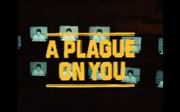 Video still. The words \"A Plague On You\" in blocky yellow font over an image of a series of video monitors.