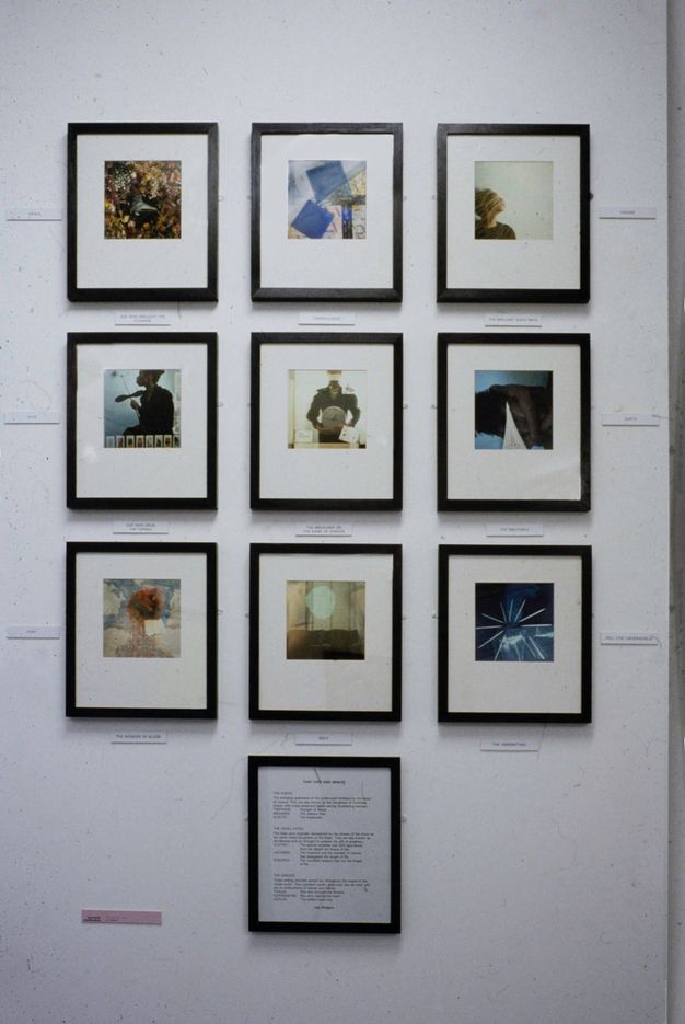 Installation photograph. A group of 10 framed, colourful artworks are hung onto a white gallery wall in a grid formation, with three rows of three, and one in the centre below.