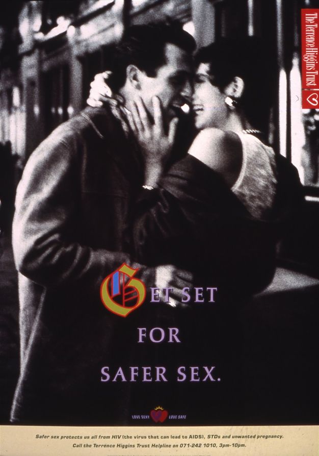 Poster. A black and white photograph of a couple smiling and embracing as they lean in towards one another. Title text underneath reads, “GET SET FOR SAFER SEX.” The decorative ‘G’ letter is yellow, red and blue, while the remaining text is purple. The Terrence Higgins Trust logo is in the upper right.