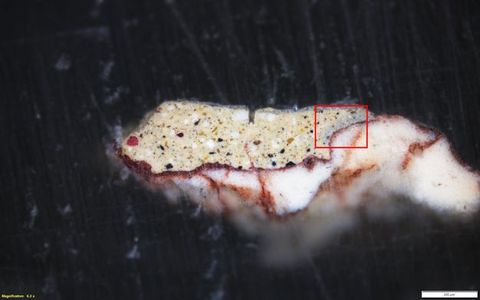 Colour photograph. A close-up photograph of a colourful rock or mineral set against a black, textured background. On the lower left yellow text reads, ‘Magnification: 6.3 x’. On the right, a small white rectangle bears the number 200.