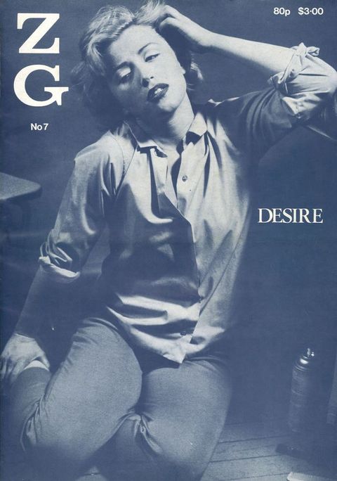 Cover of a magazine. A blue and white photograph depicts a young woman in a kneeling pose, facing the camera with eyes looking down. Her left arm is raised and pushes back her hair, while her right arm reaches back towards her ankle. She wears a shirt with sleeves rolled, and tight jeans. In the background is a can of hairspray, furniture, and wood flooring. The photo is overlain with text reading, ‘ZG’, along with ‘No 7’, and, ‘Desire’. 