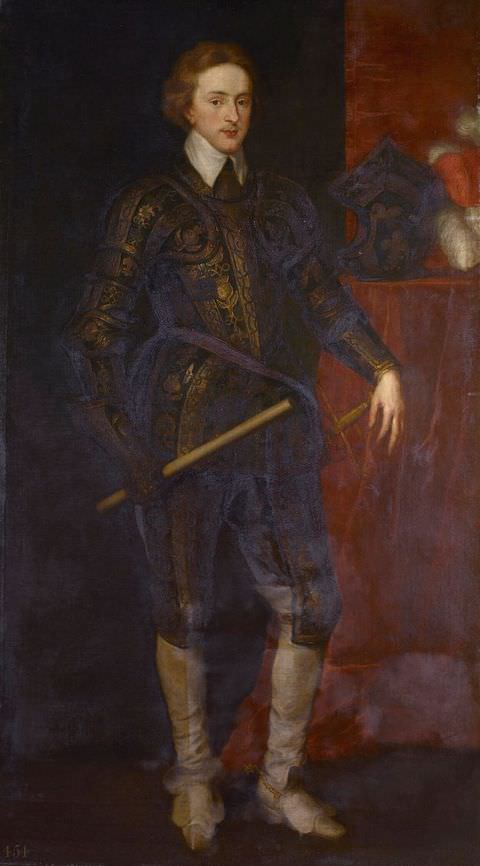 Painting. A full-length portrait of a young man dressed in dark, fitted historical clothing decorated with passages of gold pattern. He wears knee-length white boots and carries a long stick in one hand. Behind him, a table to the right of the image holds a dark hat or helmet.