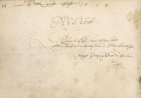 Colour photograph. Documentation of a handwritten note on white, aged paper with various patches of light brown staining. A passage of upper-case lettering forms a title, and lower case, intricate cursive writing is scrawled above and below it.