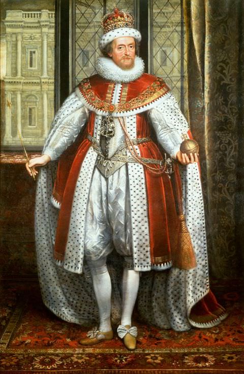 Painting. A full-length portrait of a man dressed in formal, royal clothing in shades of red and white, including a long, fur lined cape, and a fur lined crown. He holds a golden orb bearing a cross in one hand, and a baton bearing a cross in the other. The man stands on an ornate rug, while a window behind him shows the façade of a building in the distance.