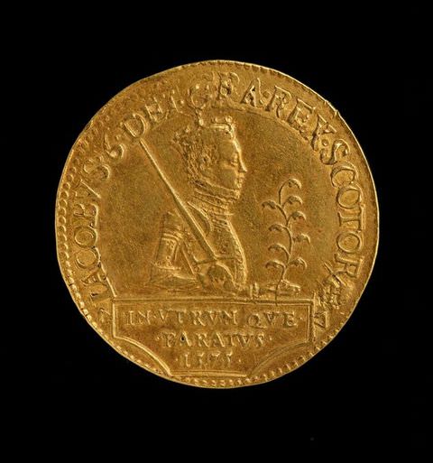 Colour photograph. A circular golden coin documented against a black backdrop. The coin features the portrait of a young man wearing armour and a crown, with a sword leaning on one shoulder, and a plant cutting in the other hand. A passage of text encircles the circumference of the coin.