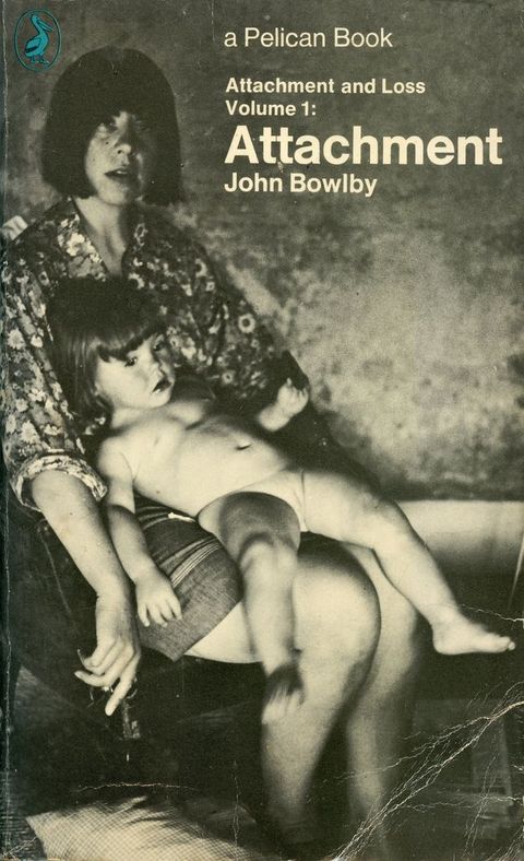 Colour photograph. The cover of a book, in which a woman is seen seated with a naked young child spread out across her lap. The book title reads, 'Attachment', by John Bowlby.