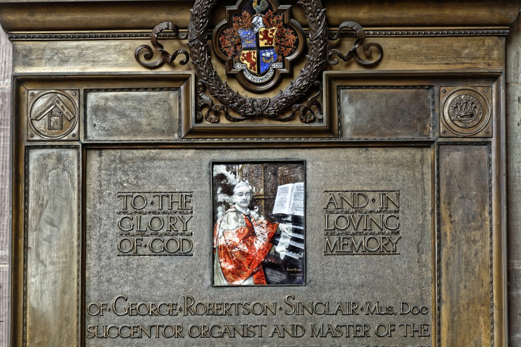 with a relief showing Sinclair at the organ console, signed by Fanny Bunn, at Hereford Cathedral.
